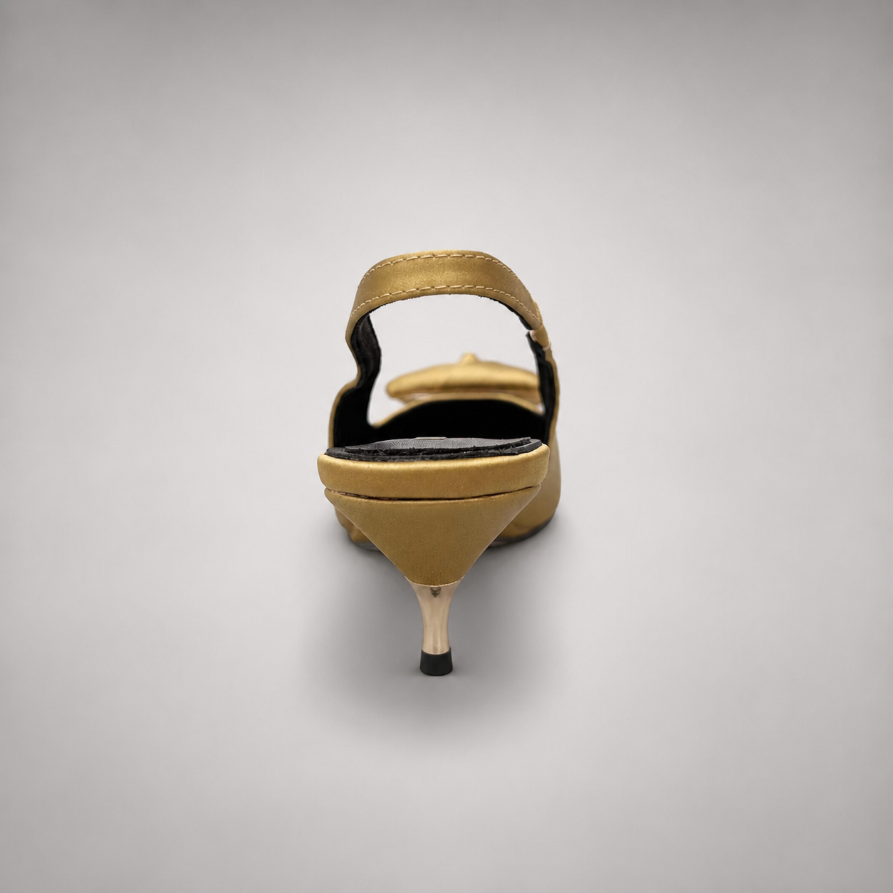 Gold slingback pump rear view showing a pointed toe and bow detail
