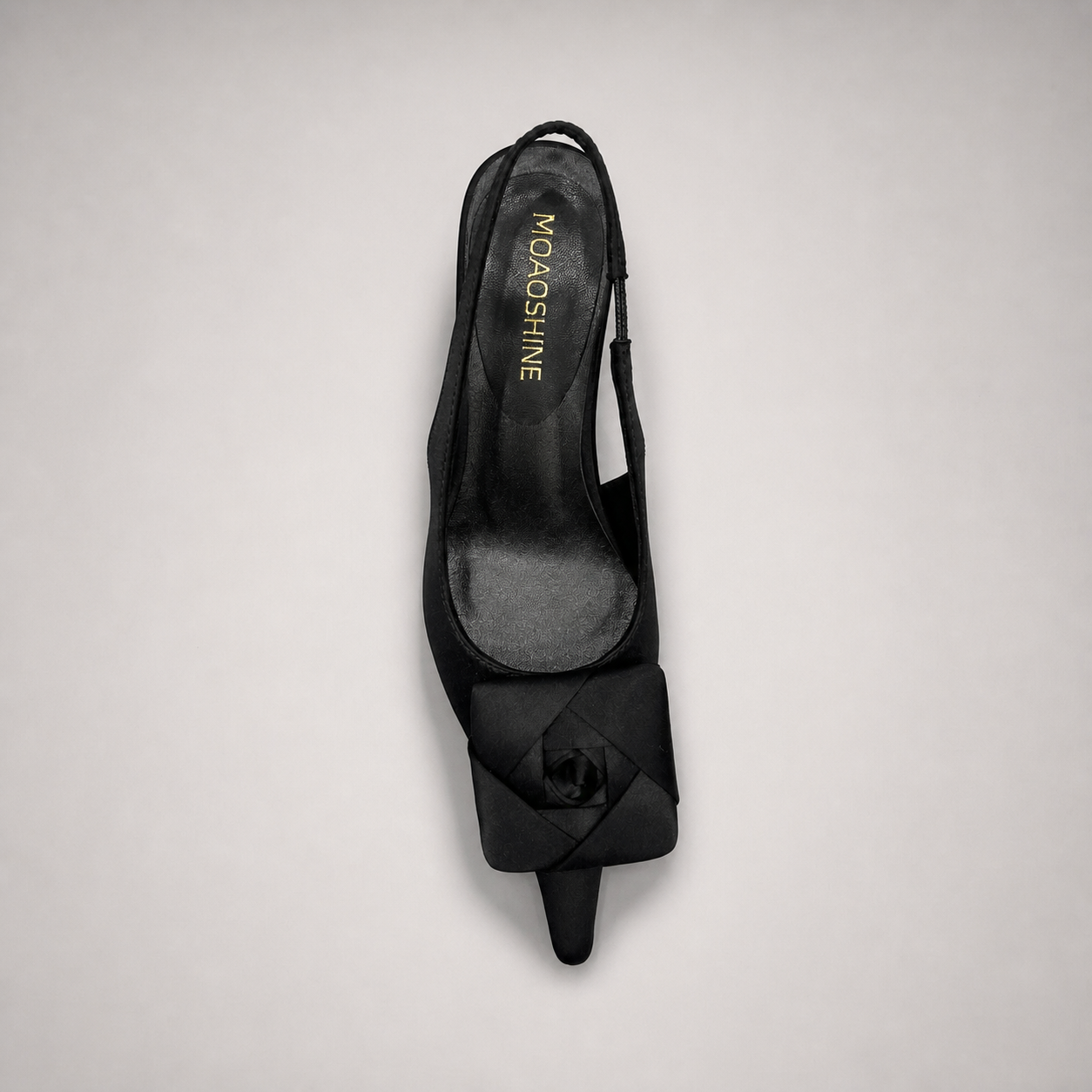 Black slingback pump top view showing a pointed toe and bow detail