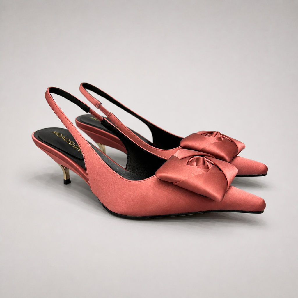 Pink slingback pump pair three-quarter view showing a pointed toe and bow detail
