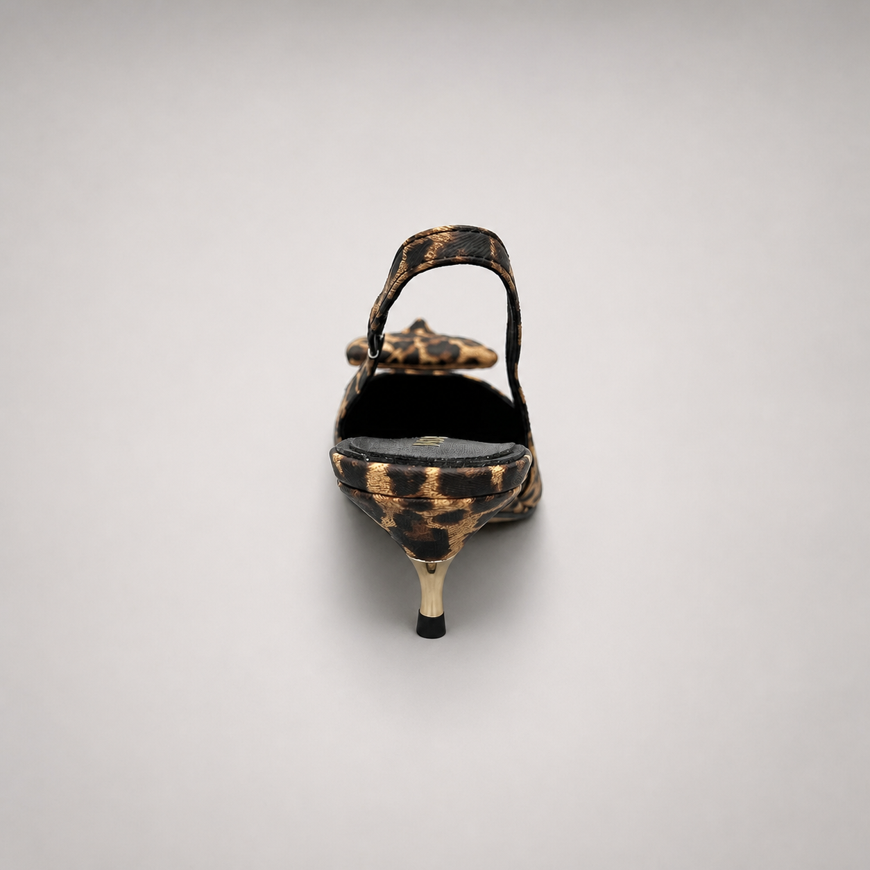 Brown slingback pump rear view showing a leopard-print upper and bow detail