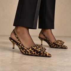 Brown leopard-print bow slingback pumps worn with black tailored trousers