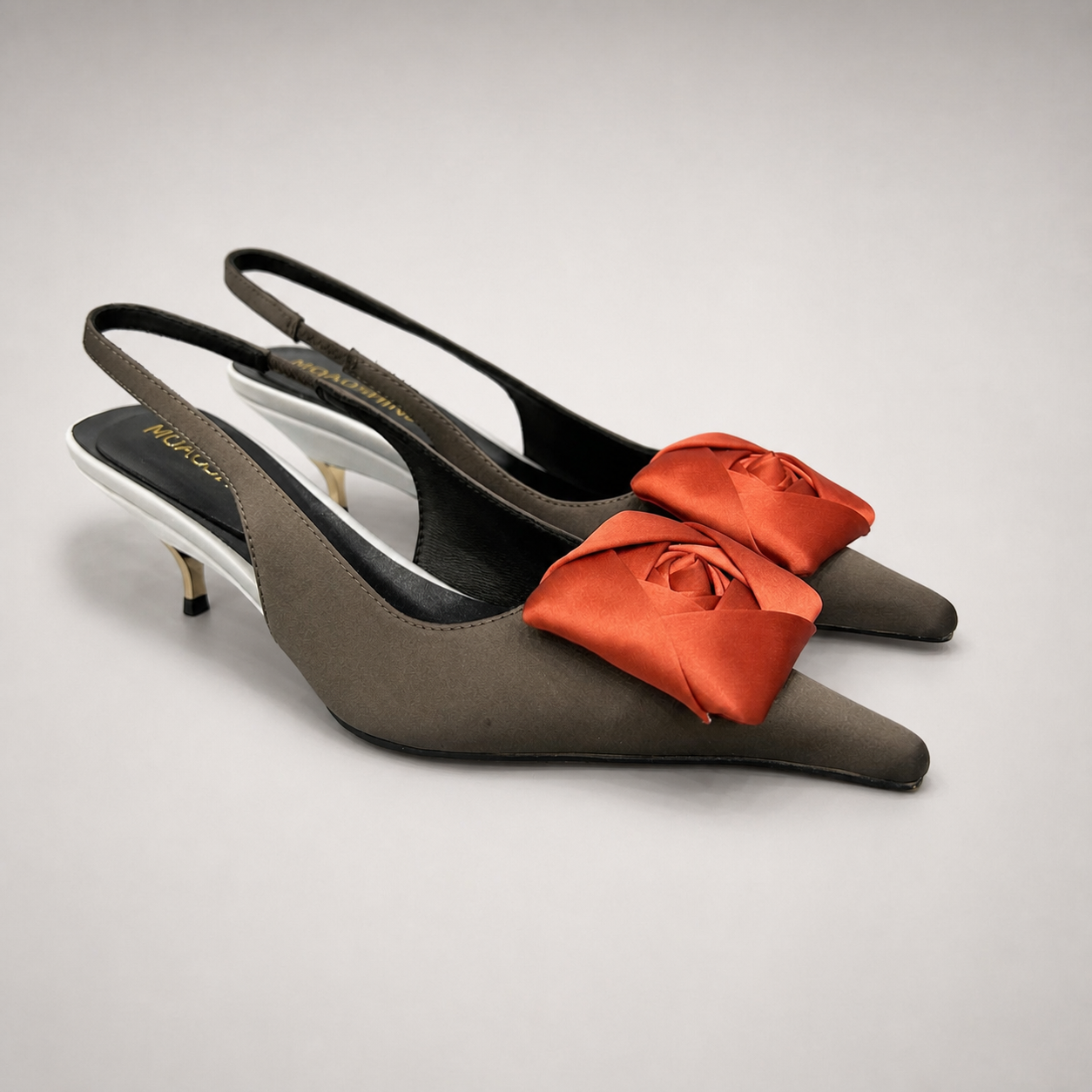 Black slingback pump pair three-quarter view showing a pointed toe and bow detail