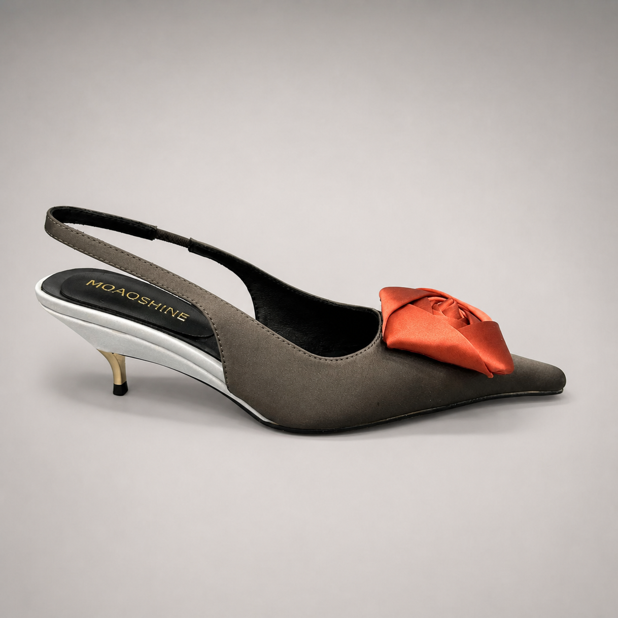 Black slingback pump side profile showing a pointed toe and bow detail