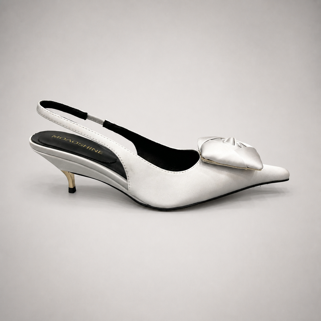 White slingback pump side profile showing a pointed toe and bow detail
