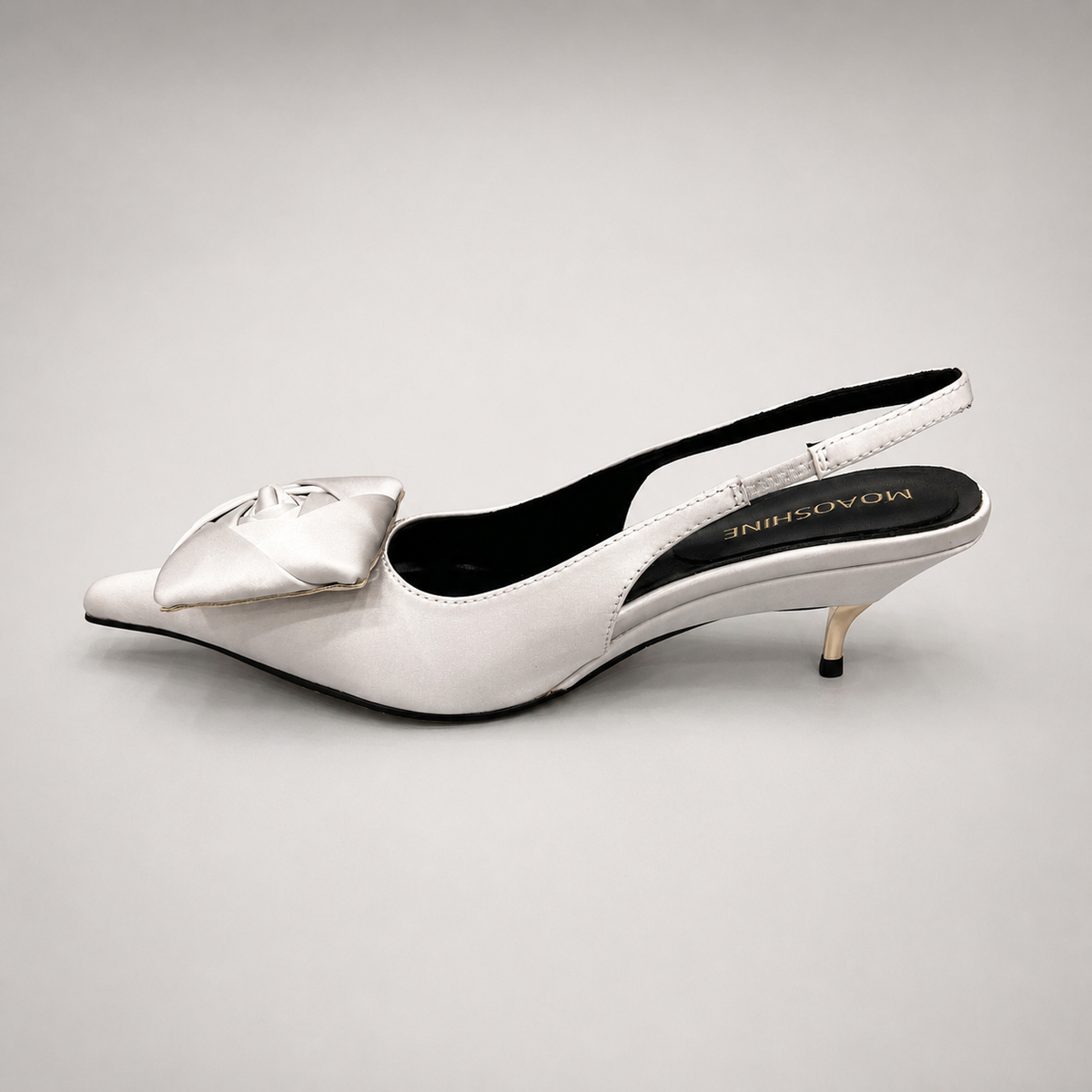 White slingback pump opposite side profile showing a pointed toe and bow detail