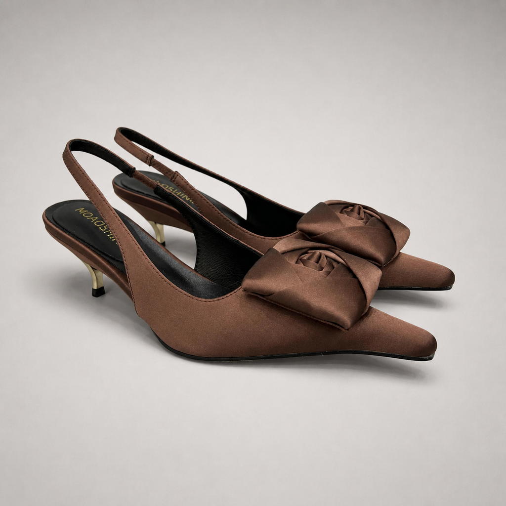 Brown slingback pump pair three-quarter view showing a pointed toe and bow detail