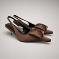 Brown slingback pump pair three-quarter view showing a pointed toe and bow detail