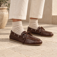 Dark brown croc-embossed oil-waxed leather boat shoes worn with ivory cropped trousers and oatmeal socks