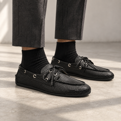 Black snake-embossed oil-waxed leather boat shoes worn with charcoal trousers and black socks