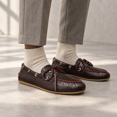Burgundy snake-embossed oil-waxed leather boat shoes worn with grey trousers and oatmeal socks