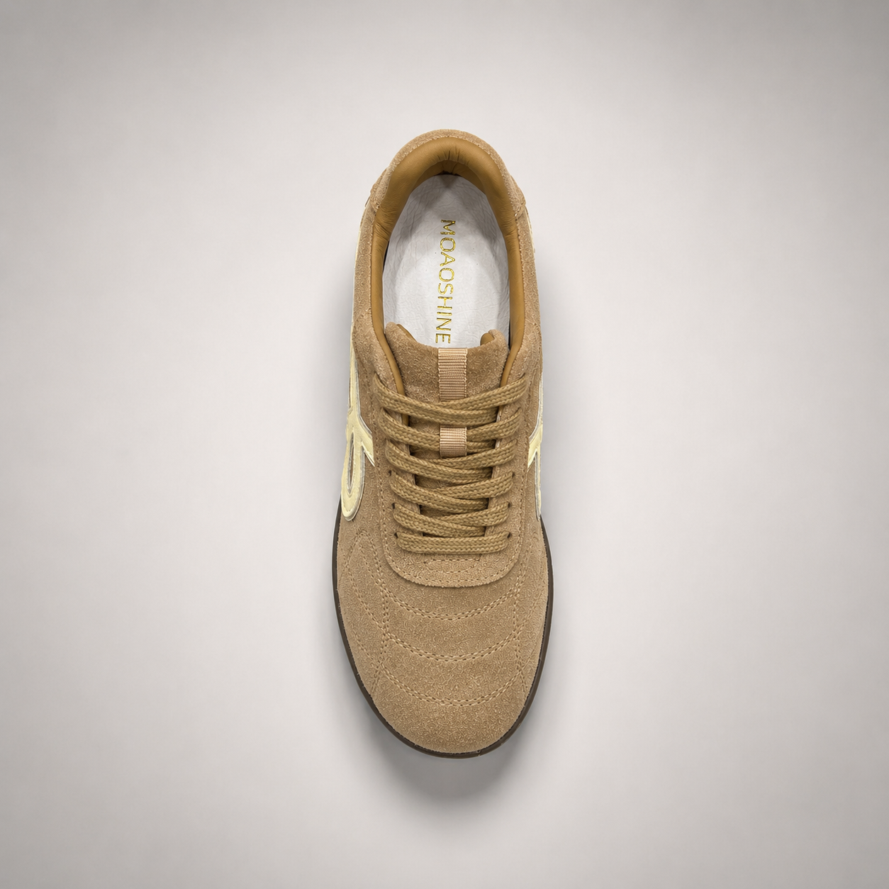 Tan soccer shoe second top angle showing a lace-up upper and molded outsole studs