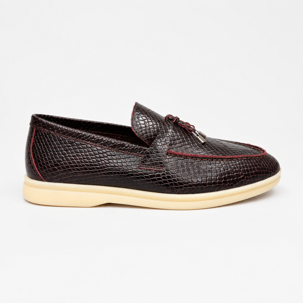 Burgundy loafer side profile showing a snakeskin-pattern embossed vamp and tassel detail