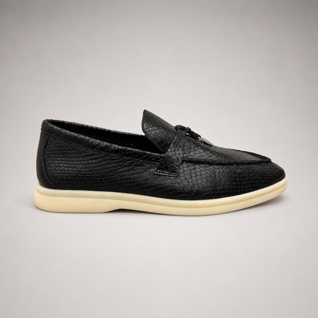 Black loafer side profile showing a snakeskin-pattern embossed vamp and tassel detail