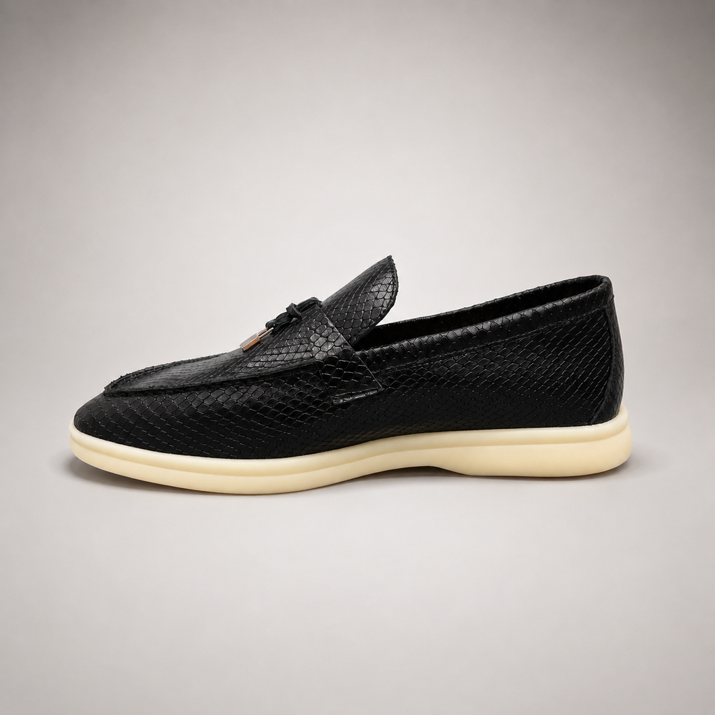 Black loafer opposite side profile showing a snakeskin-pattern embossed vamp and tassel detail