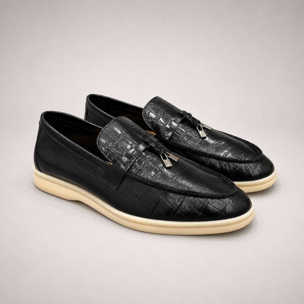 Black loafer pair three-quarter view showing a crocodile-pattern embossed upper and metal accent
