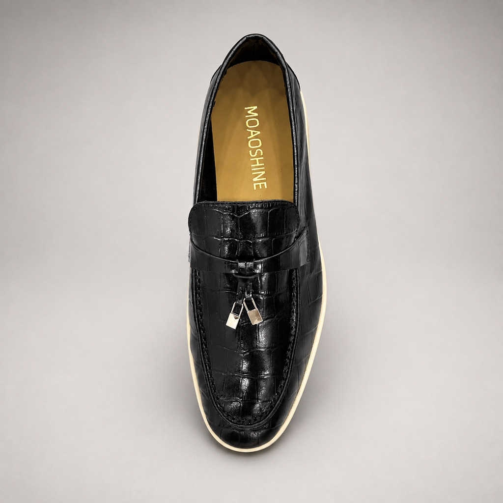 Black loafer top view showing a crocodile-pattern embossed upper and metal accent