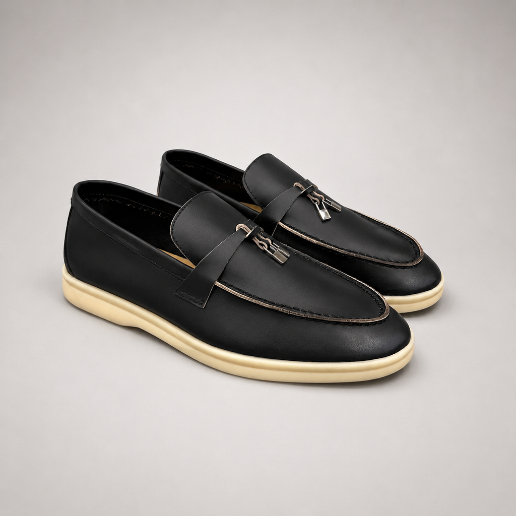 Black loafer pair three-quarter view showing a metal accent across the vamp