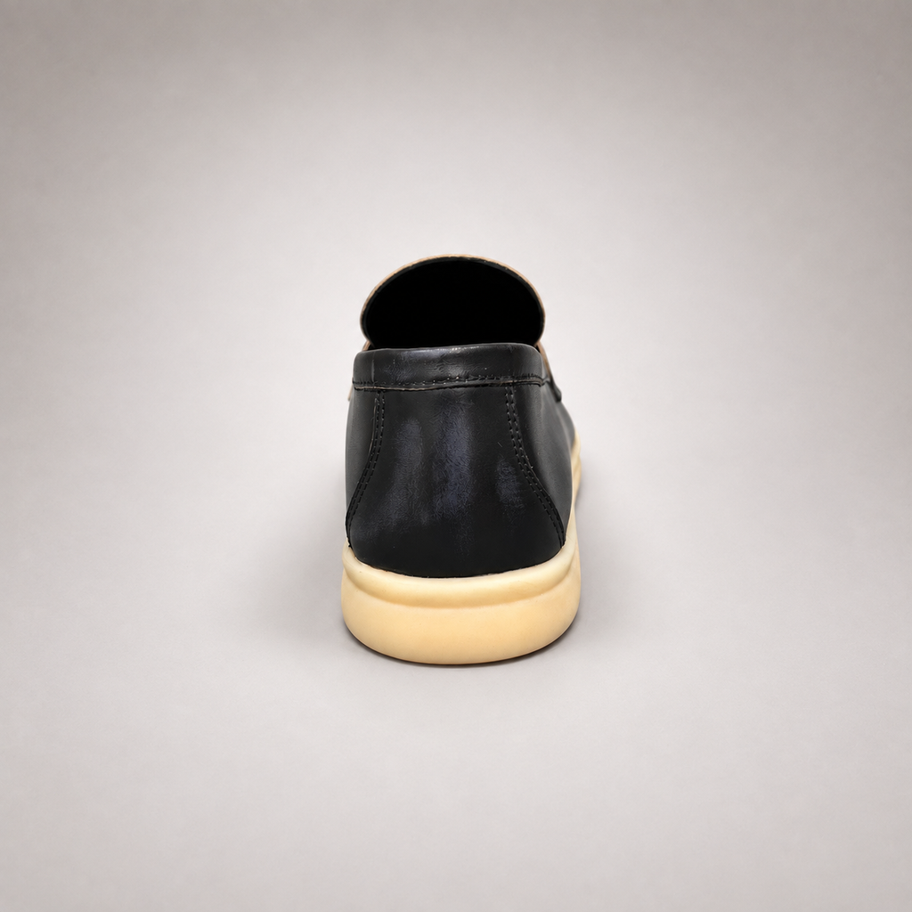 Black loafer rear view showing a metal accent across the vamp