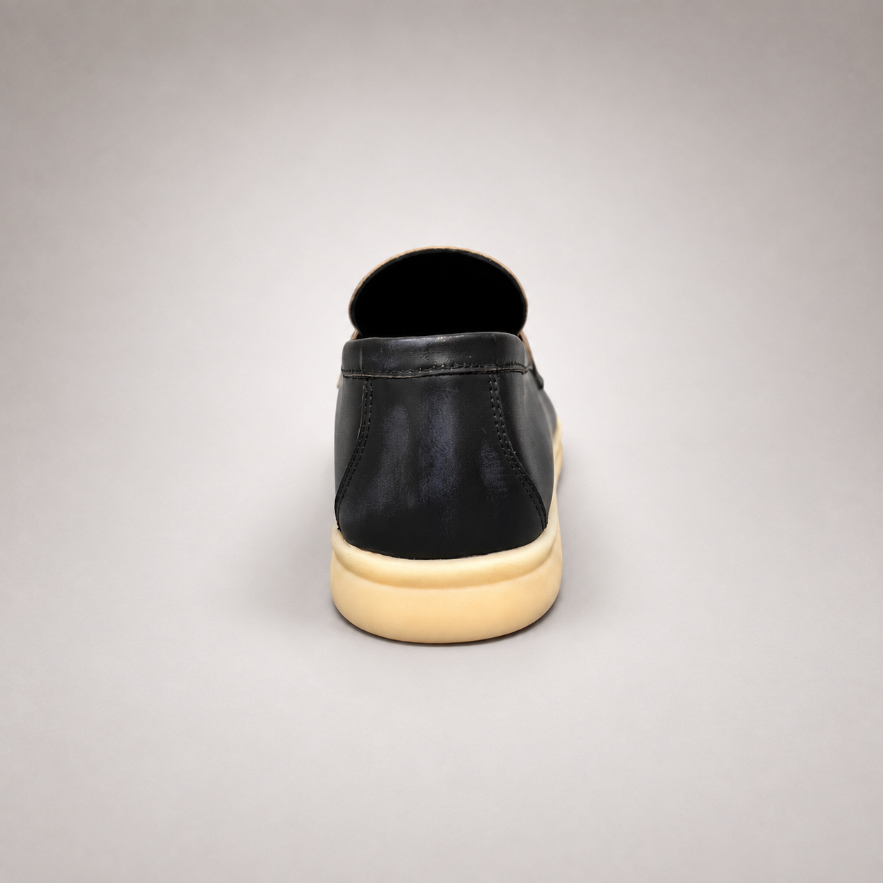 Black loafer rear view showing a metal accent across the vamp