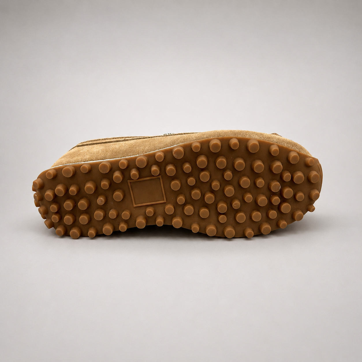 Tan moccasin sneaker top view showing fringe and tassel details over the laces
