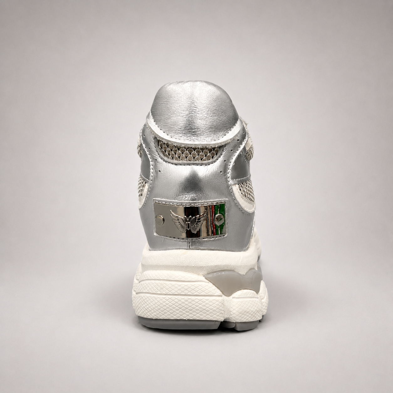 Silver sneaker rear view showing a panelled lace-up upper