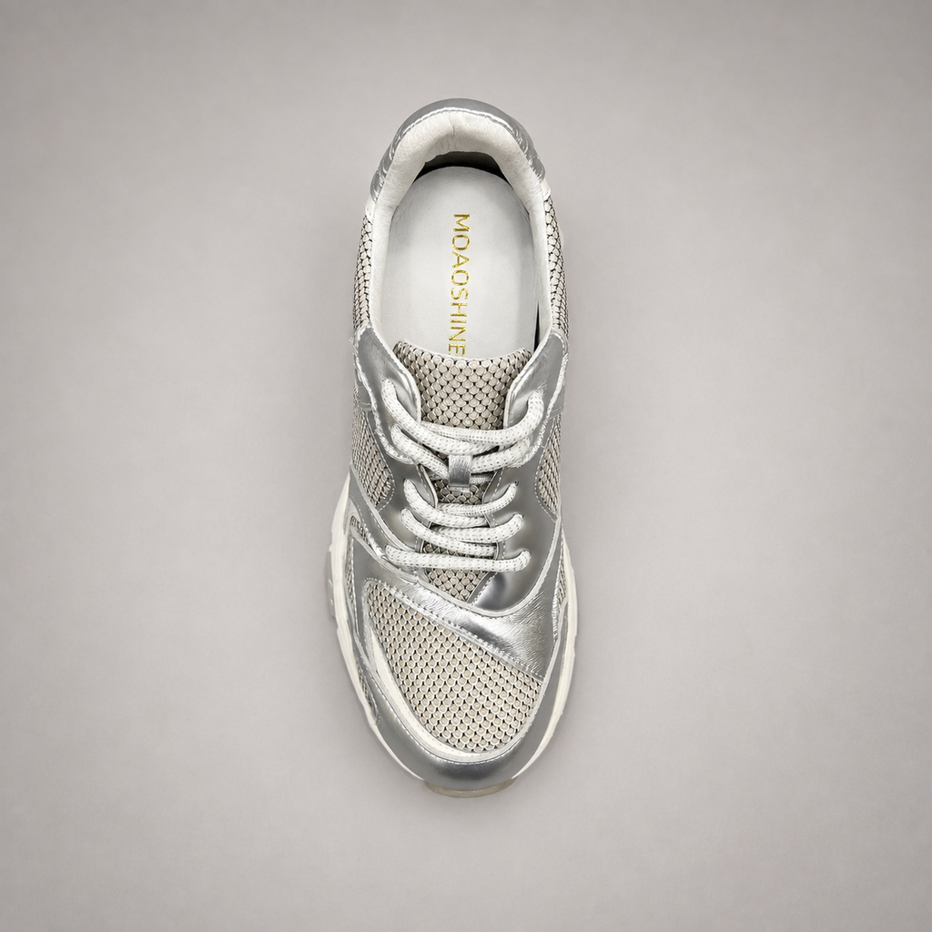 Silver sneaker top view showing a panelled lace-up upper