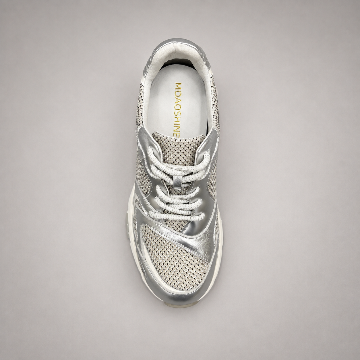 Silver sneaker top view showing a panelled lace-up upper