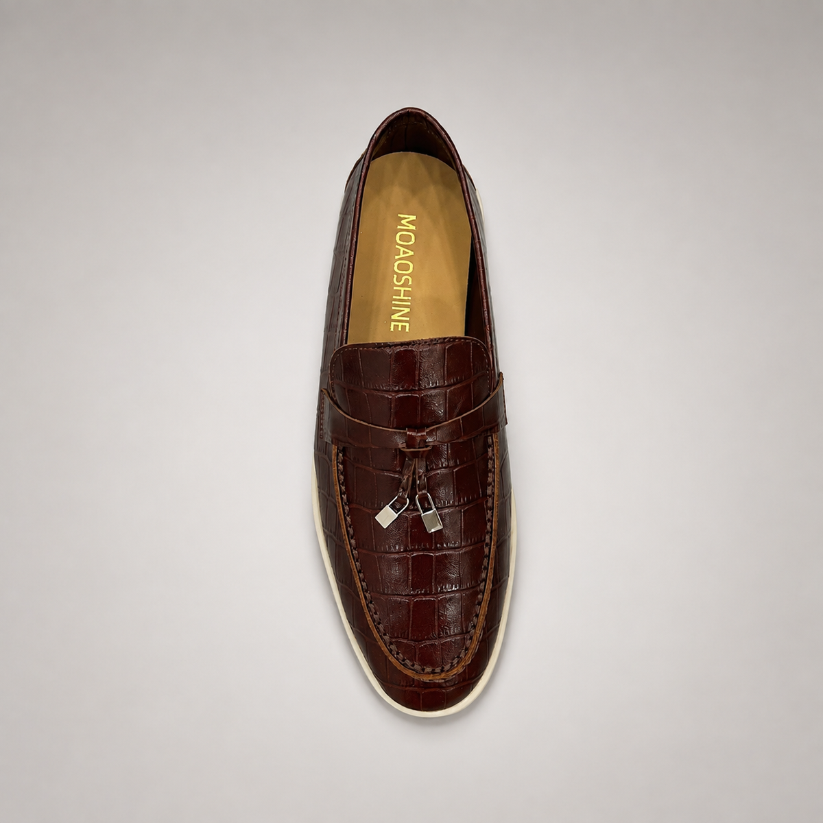Brown loafer top view showing a crocodile-pattern embossed upper and vamp strap