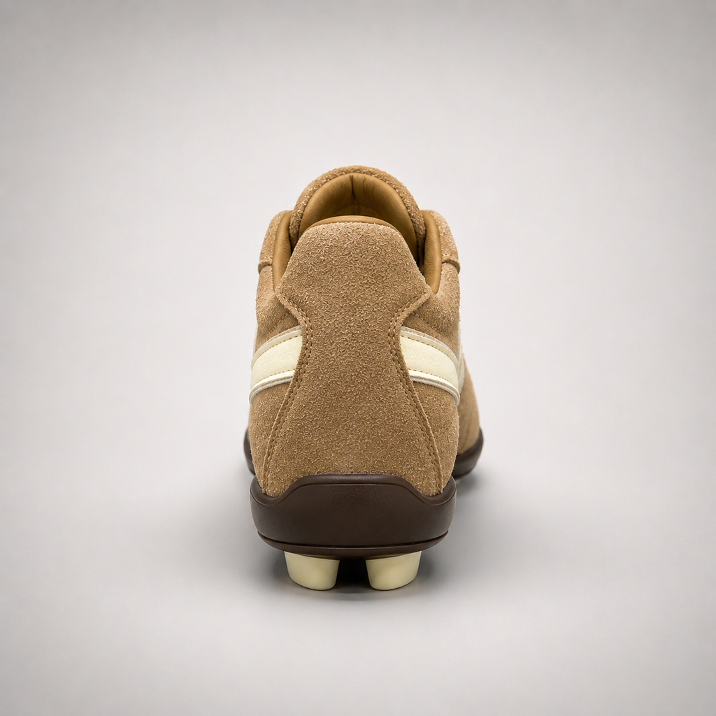 Tan soccer shoe rear view showing a lace-up upper and molded outsole studs