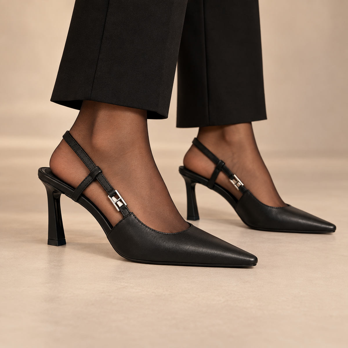 Black pointed-toe double-strap slingback pumps worn with black trousers