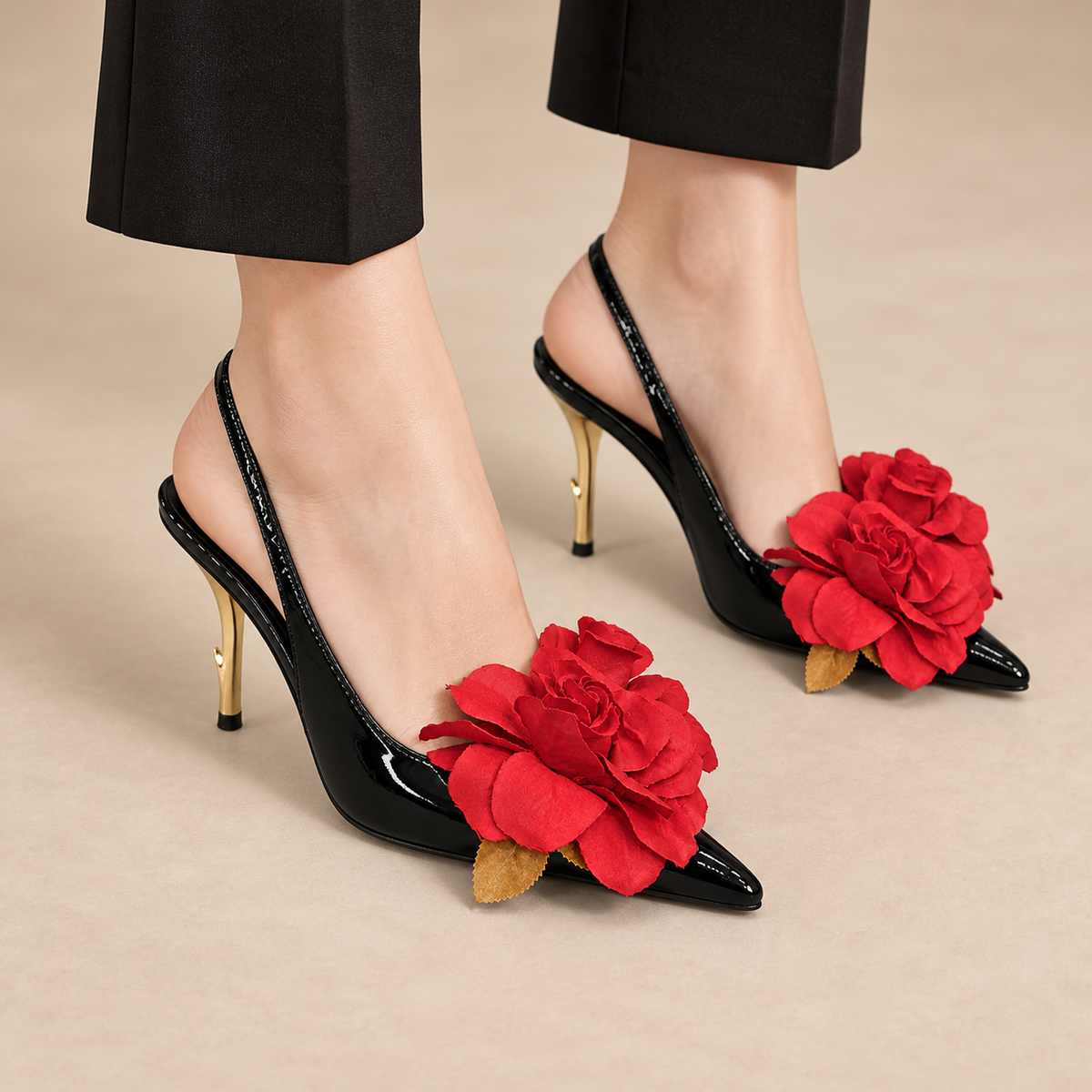Black patent pointed-toe floral-appliqu¨¦ slingback pumps worn with black trousers