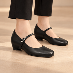 Black water-washed horse leather internal-lift Mary Jane pumps worn with black trousers