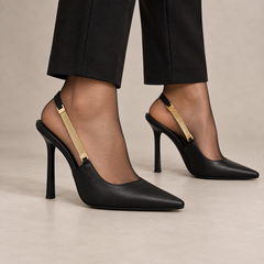 Black pointed-toe leather slingback pumps with tall heel worn with black trousers