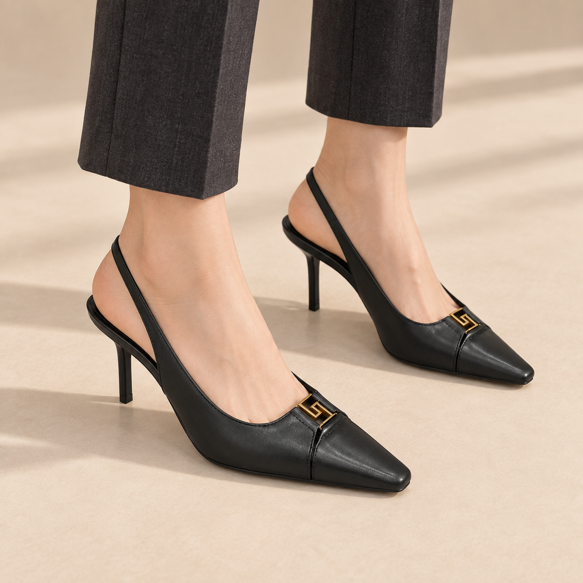 Black square-toe metal-accent slingback pumps worn with charcoal trousers
