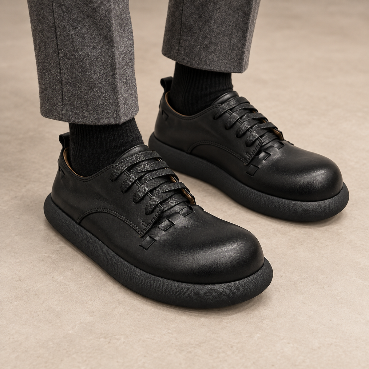 Black washed horse leather lace-up shoes worn with gray trousers and black socks