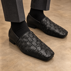 Black washed horse leather woven slip-on loafers worn with charcoal trousers and black socks