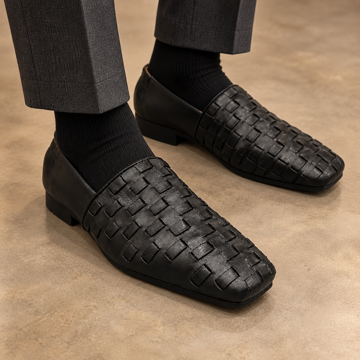 Black washed horse leather woven slip-on loafers worn with charcoal trousers and black socks