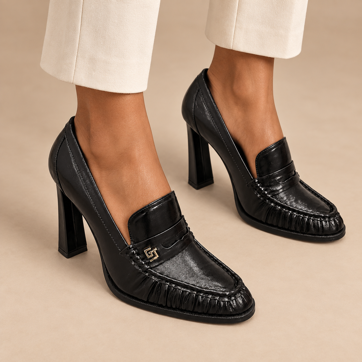 Black waxed leather block-heel loafers worn with ivory trousers