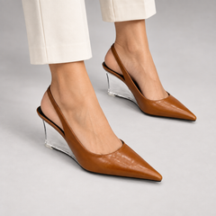 Brown pointed-toe clear-wedge slingback pumps worn with ivory trousers