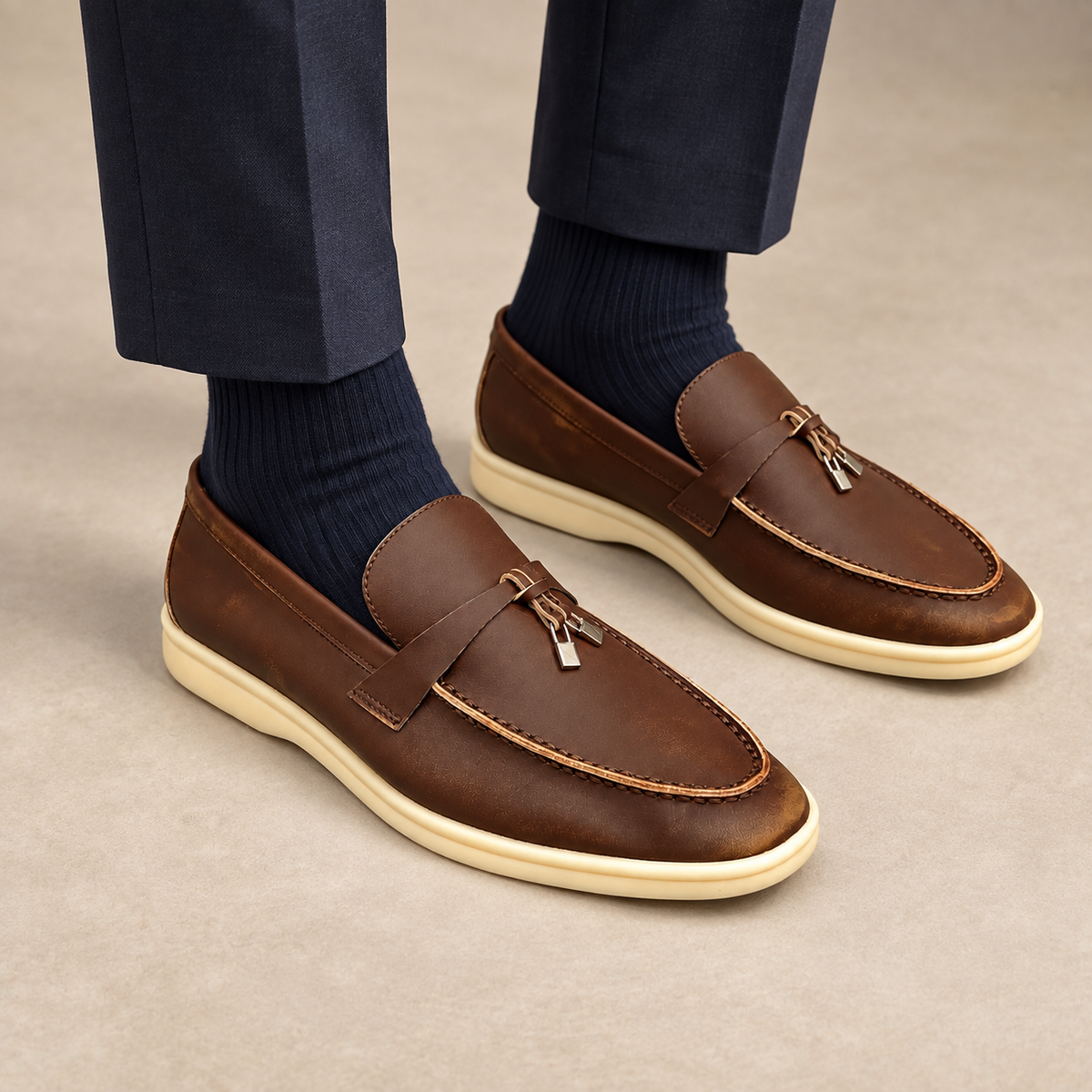 Brown metal-accent loafers worn with navy trousers and navy socks