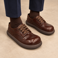 Brown washed horse leather lace-up shoes worn with navy trousers and brown socks