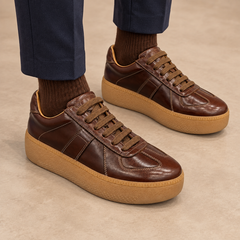 Brown washed horse leather platform sneakers worn with navy trousers and brown socks