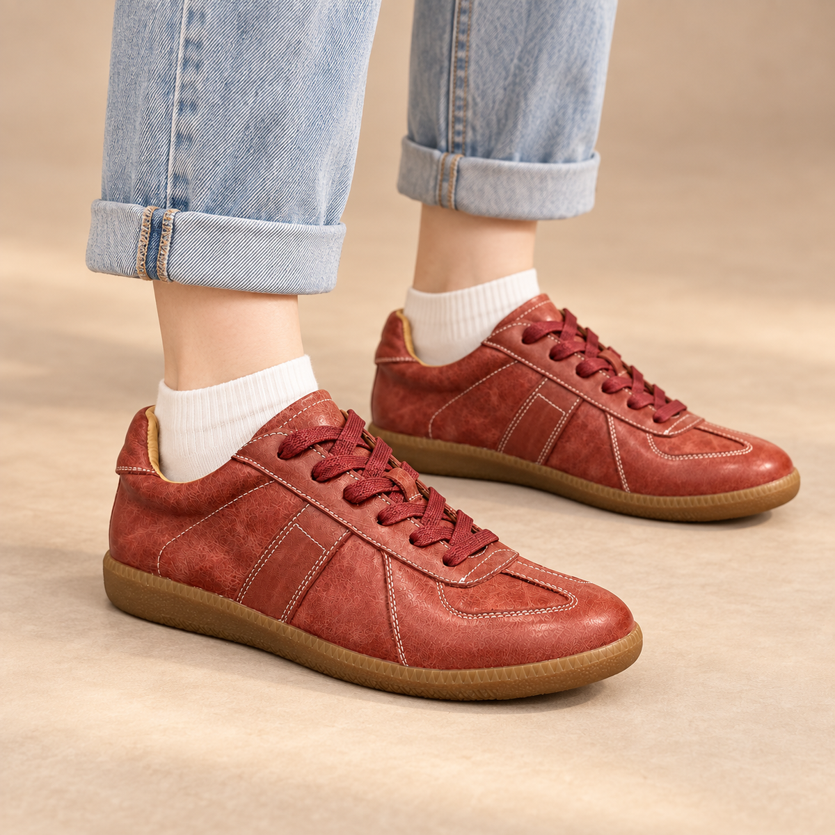 Burgundy water-washed horse leather lace-up sneakers worn with cuffed jeans and white socks