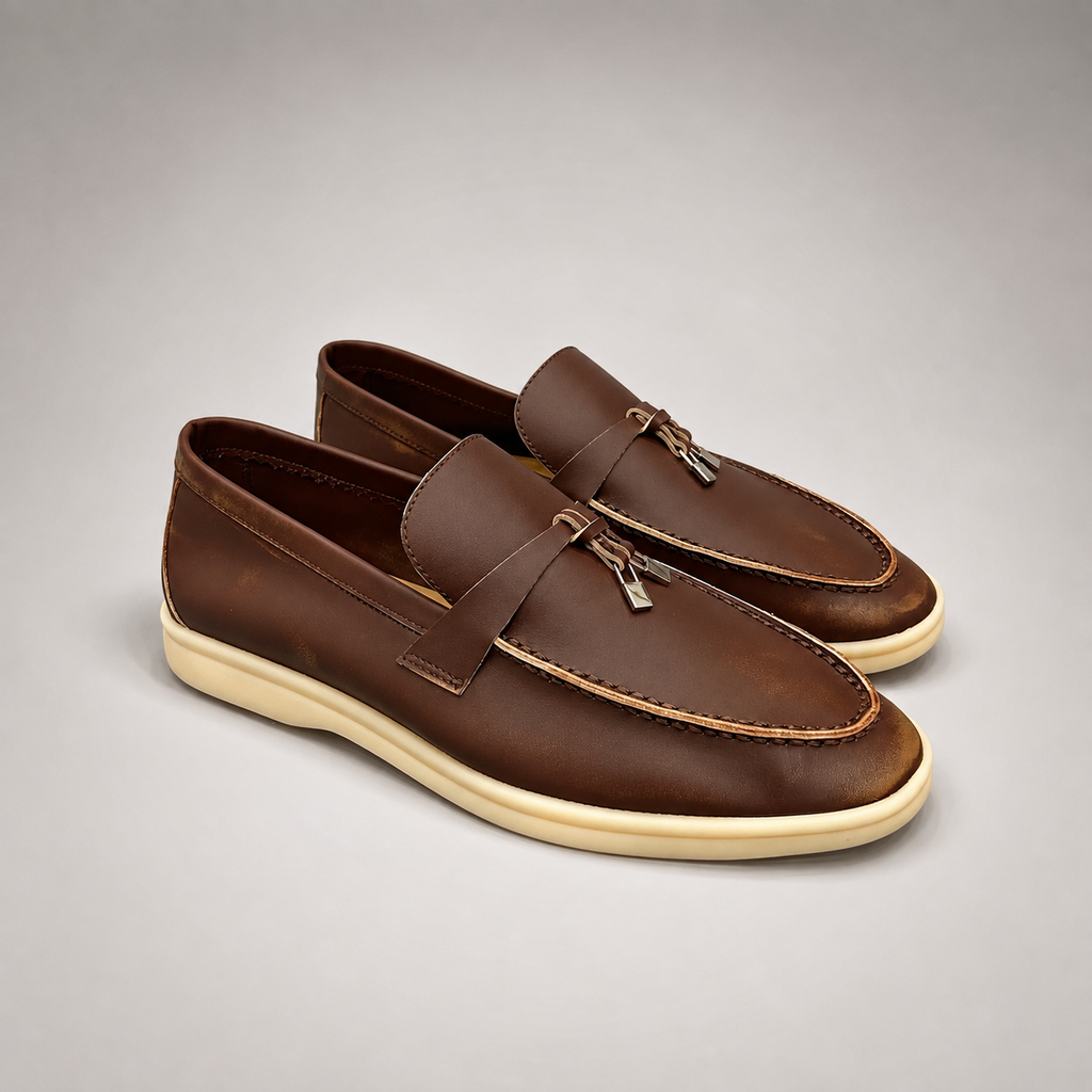 Brown loafer pair three-quarter view showing a metal accent across the vamp