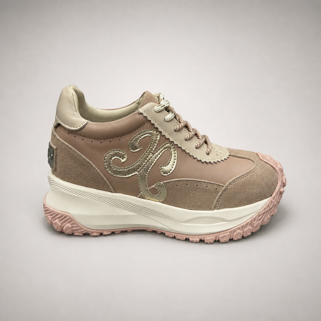 Pink sneaker side profile showing a panelled lace-up upper