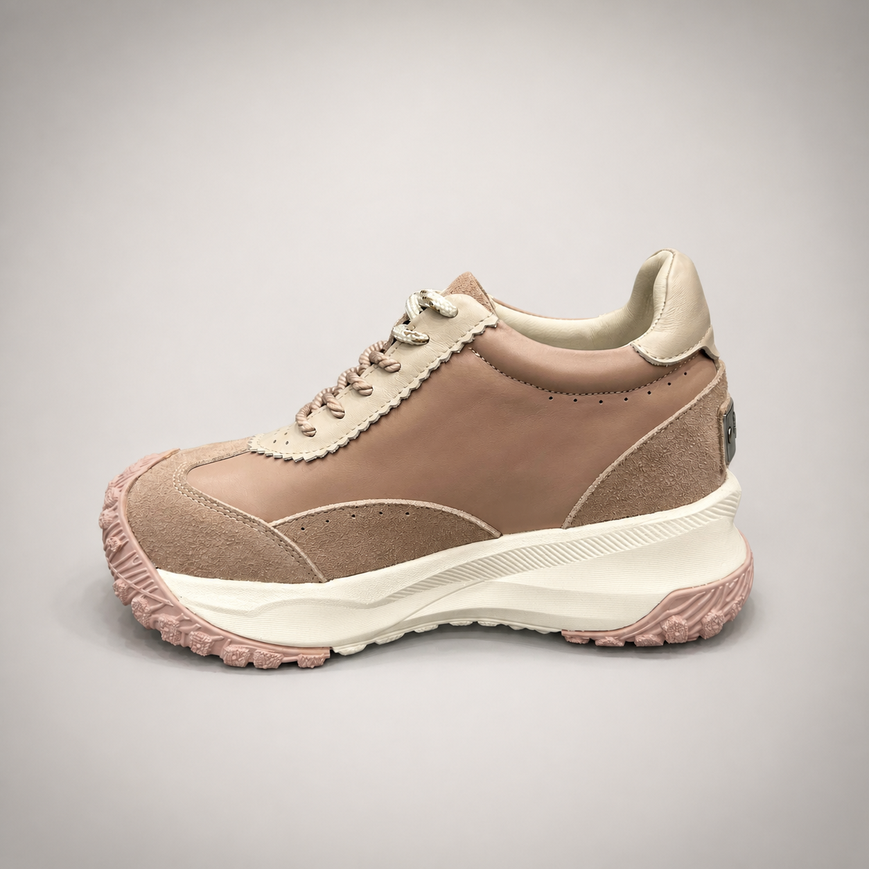 Pink sneaker opposite side profile showing a panelled lace-up upper