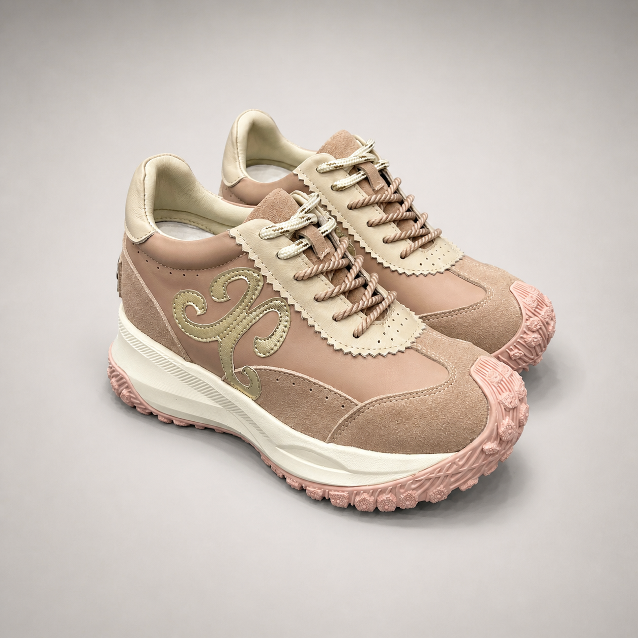 Pink sneaker pair three-quarter view showing a panelled lace-up upper