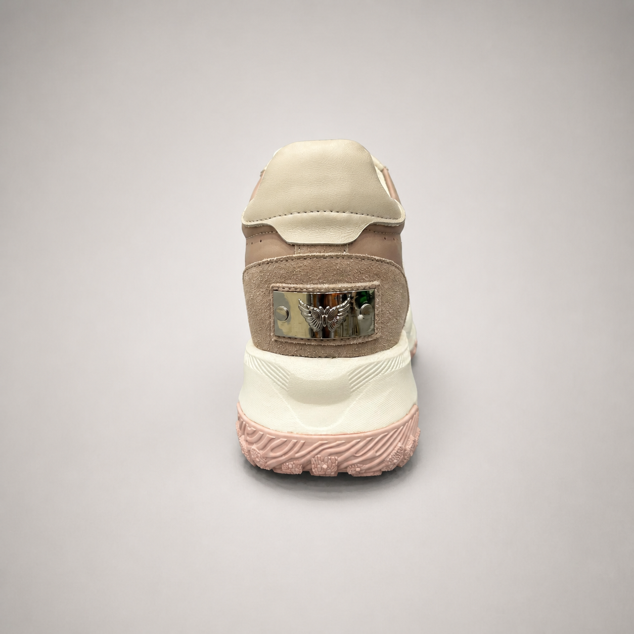 Pink sneaker rear view showing a panelled lace-up upper