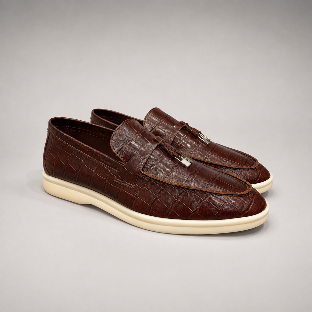 Brown loafer pair three-quarter view showing a crocodile-pattern embossed upper and vamp strap