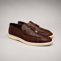 Brown loafer pair three-quarter view showing a crocodile-pattern embossed upper and vamp strap
